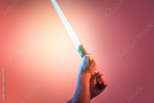 Canvas Print a fantastic  sword lightsaber in the hands of a man