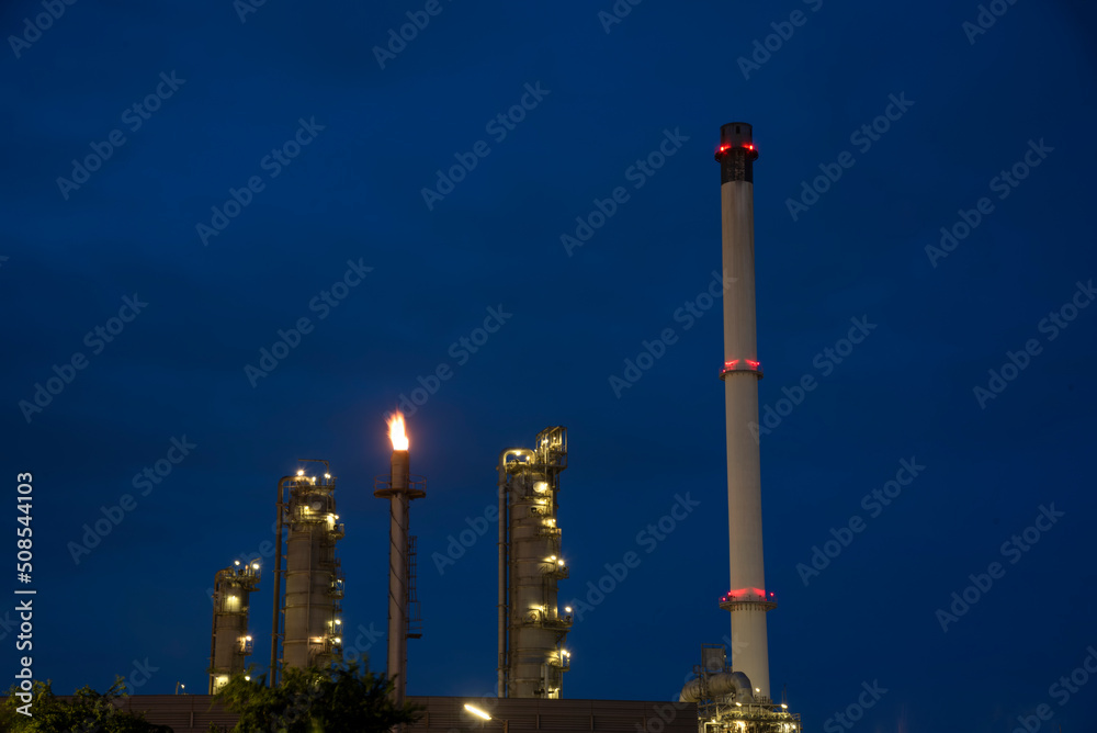 Oil refinery plant chemical factory and power plant with many storage tanks and pipelines at sunset