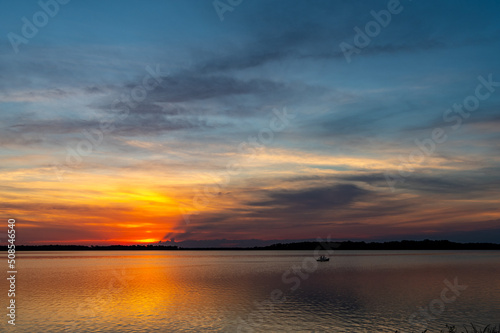 Fishing Boat at Sunset with Colorful Reflections on Lake