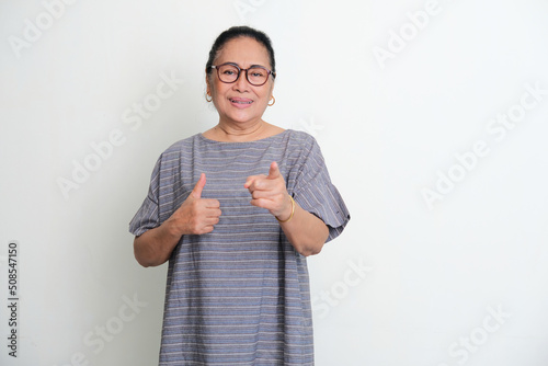 Elderly Asian women pointing finger forward and give thumb up photo