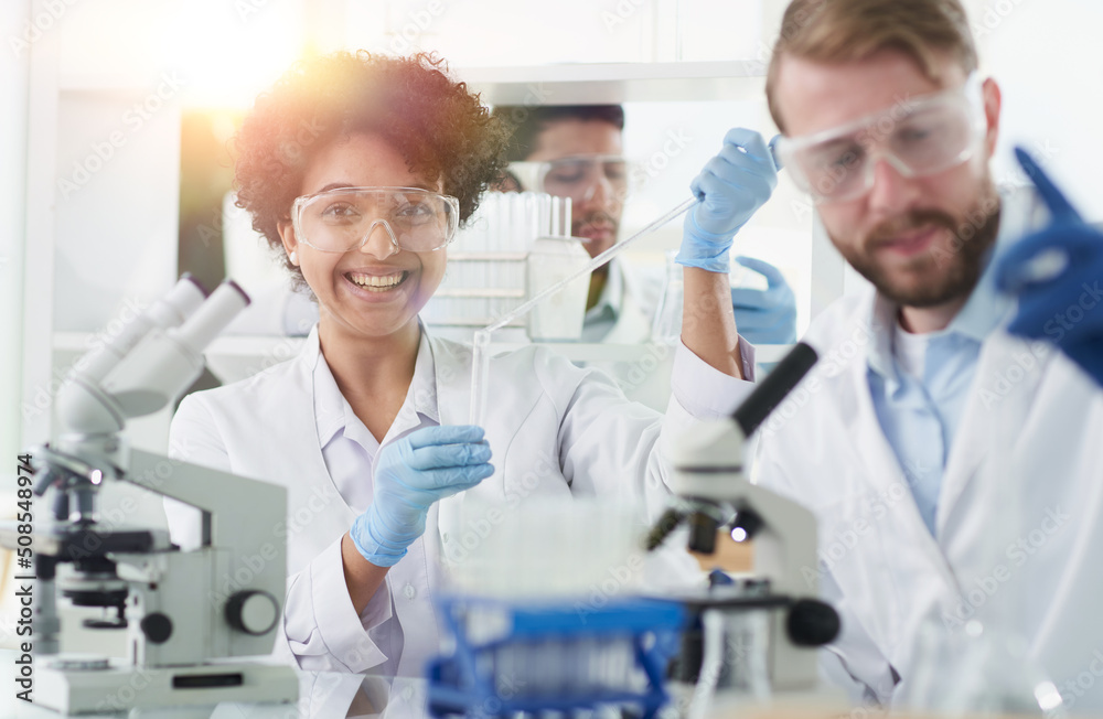 Smiling scientists looking at camera arms crossed in laboratory Smiling scientists looking at camera arms crossed in laboratory