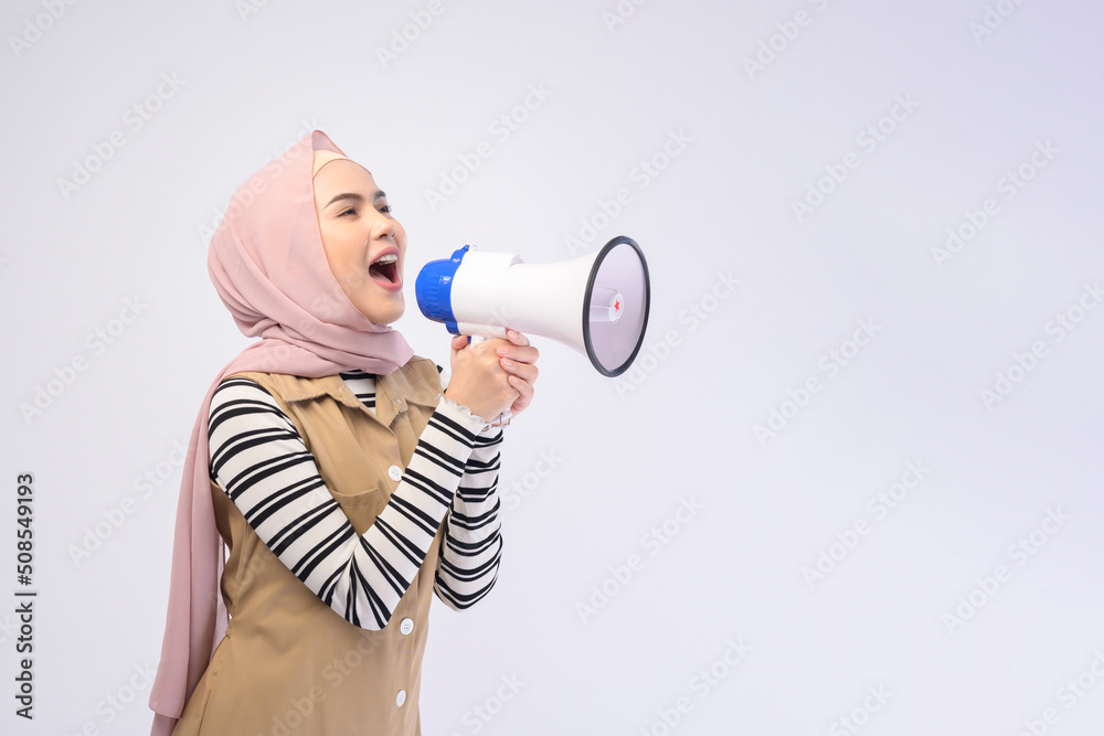Happy muslim woman is announcing with megaphone on white background Happy muslim woman is announcing with megaphone on white background