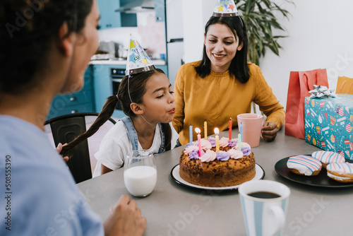 Latinx LGBTQ women mother family with daughter child celebrating happy birthday at home in Latin America