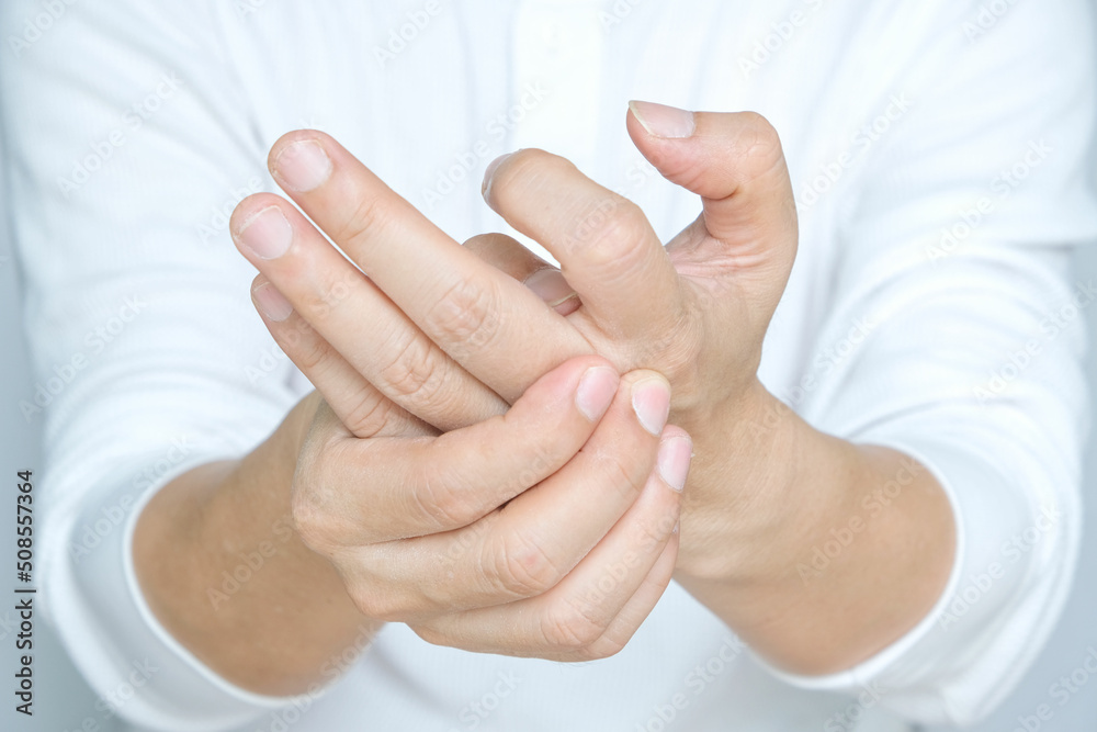 Man's hands are sore and fingers are locked. He squeezed his thumb and