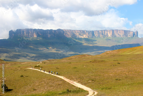 Mochileiros percorrem a trilha que leva ao monte Roraima, ao fundo. Parque Nacional Pacaraima, Venezuela fronteira com Brasil e Guiana photo
