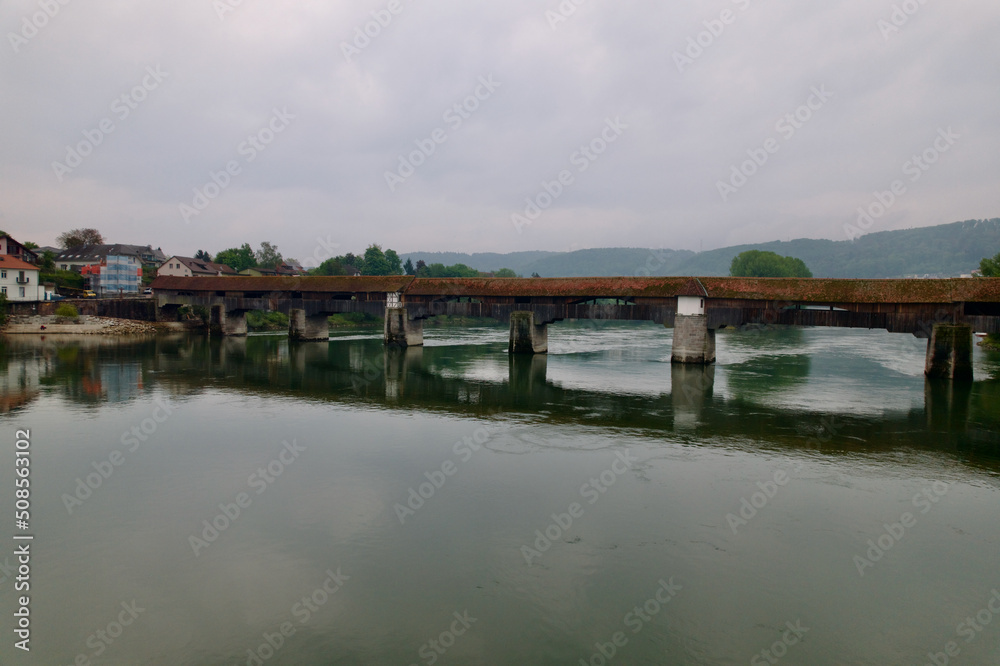Aerial view of covered wooden bridge over the Rhine River at Stein, Canton Aargau, and Bad Säckingen, Baden-Württemberg, on a cloudy spring day. Photo taken May 6th, 2022, Stein, Switzerland.