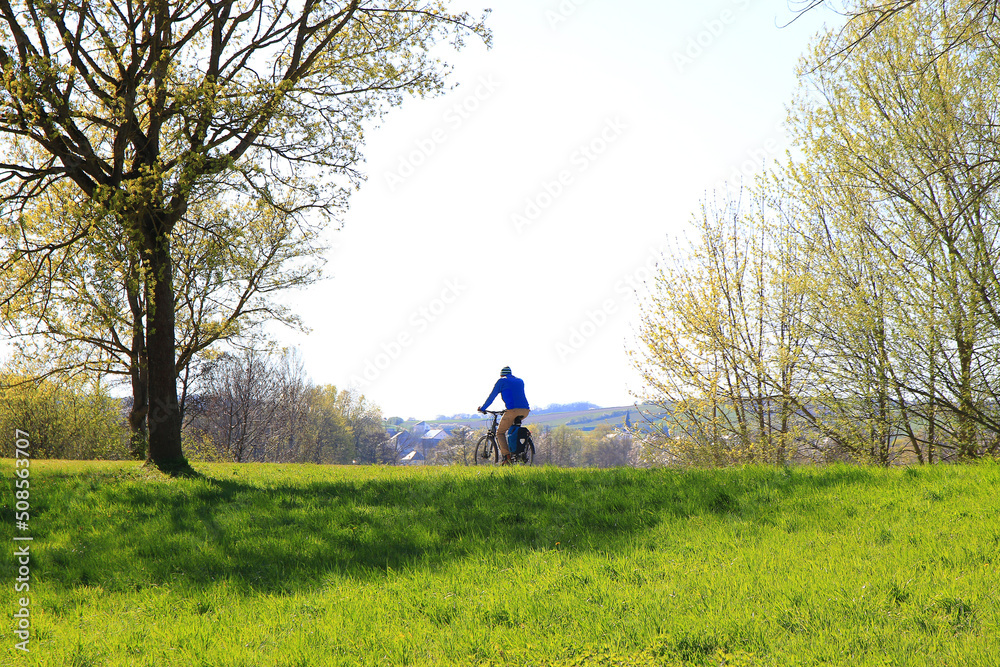 Regensburg, Germany: people are riding the bike on a rural road at sunset along Danube river in Regensburg, Germany, Europe. Regensburg, Germany: people are riding the bike on a rural road at sunset along Danube river in Regensburg, Germany, Europe.