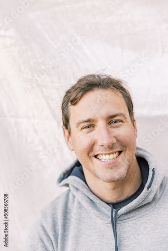 Close-up portrait of a young sports man smiling with a grey hoodie photo