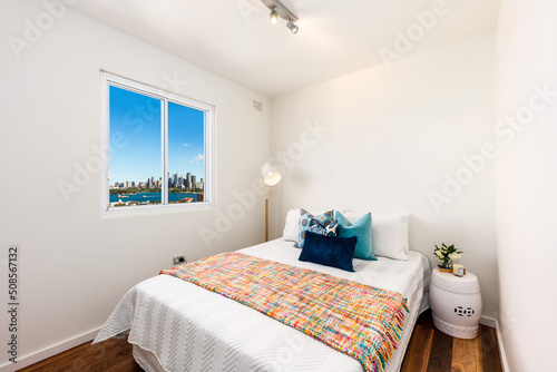 Interior of small bedroom with views of city photo