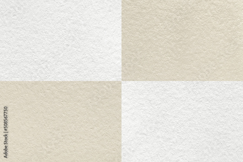 Texture of craft light beige and white paper background with cells pattern, macro. Structure of vintage kraft cardboard.