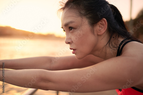Fit Asian woman doing morning exercise photo