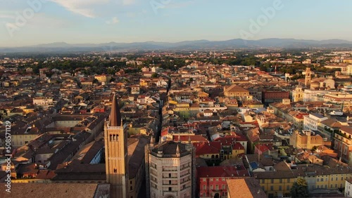parma aerial view drone wide shot of city historic center,cathedral baptistery and duomo square,flying backwards at dawn no people