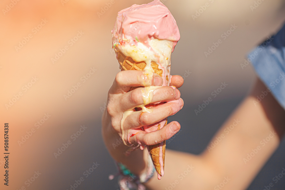 Cute girl eating ice cream on summer background outdoors. closeup portrait of adorable redhaired little girl eating ice cream.