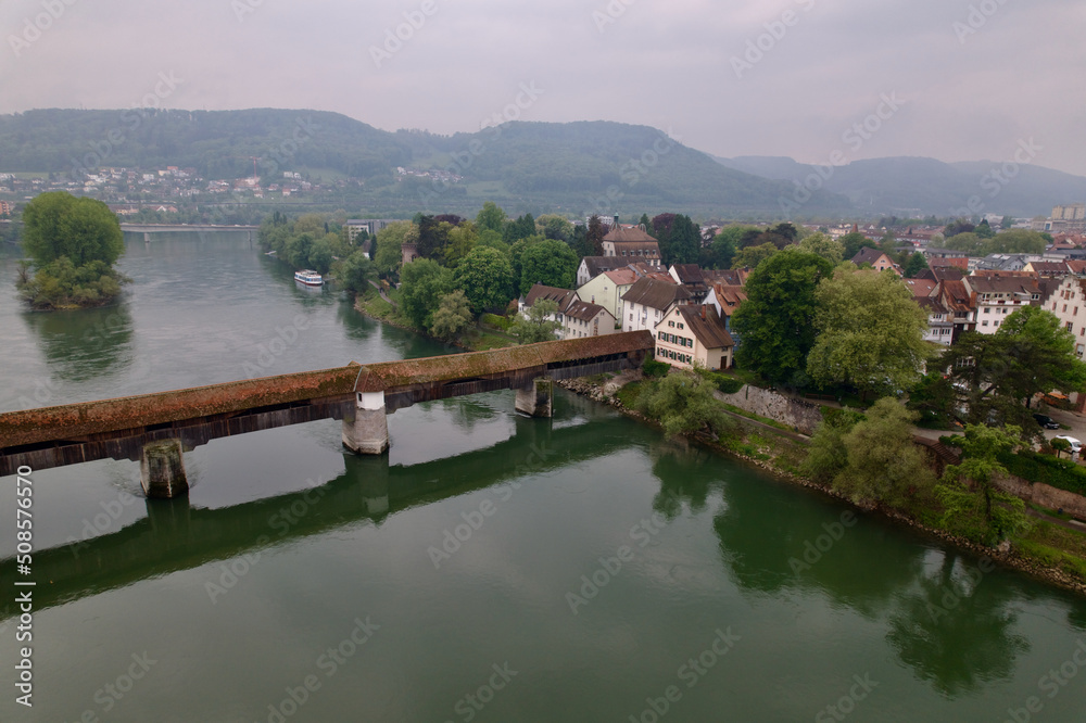 Aerial view of covered wooden bridge over the Rhine River at Stein, Canton Aargau, and Bad Säckingen, Baden-Württemberg, on a cloudy spring day. Photo taken May 6th, 2022, Stein, Switzerland. Aerial view of covered wooden bridge over the Rhine River at Stein, Canton Aargau, and Bad Säckingen, Baden-Württemberg, on a cloudy spring day. Photo taken May 6th, 2022, Stein, Switzerland.