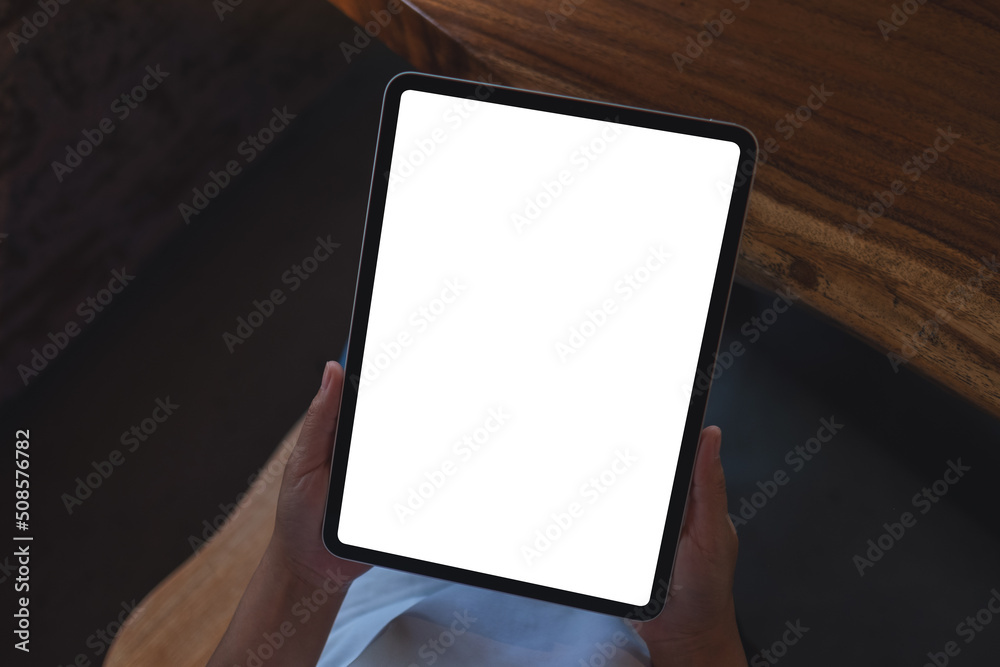 Top view mockup image of a woman holding digital tablet with blank white desktop screen Top view mockup image of a woman holding digital tablet with blank white desktop screen
