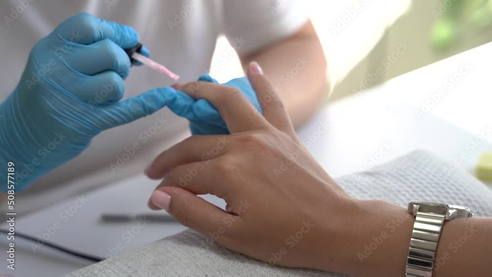 Manicurist paints nails with gel polish on clients nails. Nail polish application. Manicure service in cosmetic salon.. 4k footage Manicurist paints nails with gel polish on clients nails. Nail polish application. Manicure service in cosmetic salon.. 4k footage