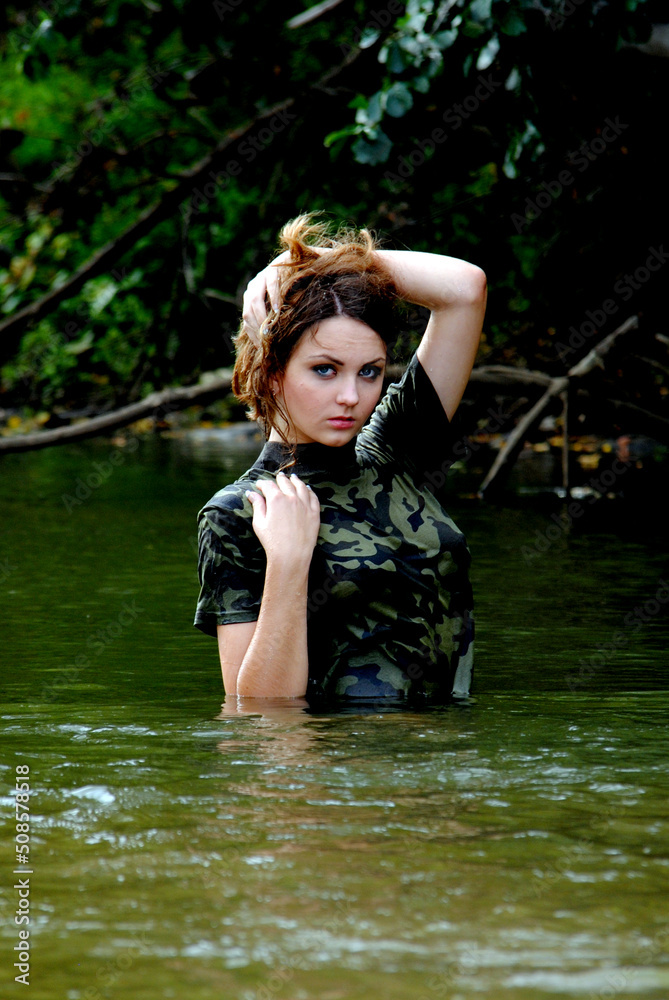 Fototapeta premium Ukrainian military girl with a paddle on the river near the kayak