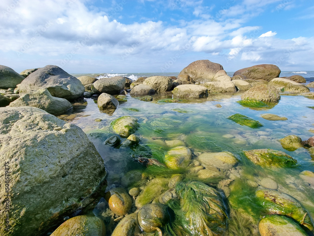 Ostseestrand mit Steinen im seichten Wasser