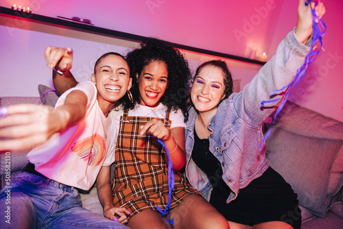 Three girlfriends having a good time at a house party photo