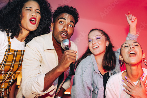 Friends singing together on karaoke night photo
