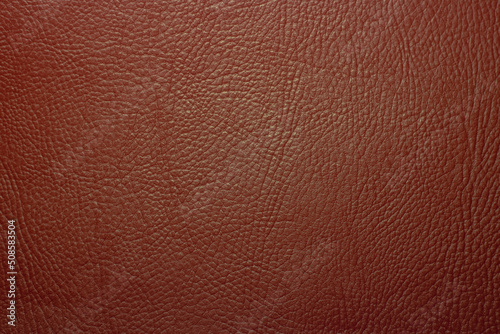Photo of the texture of red leather fabric. Leather background for text. The texture of genuine leather.