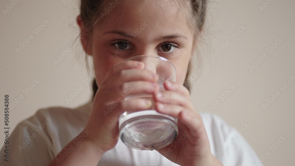 child drinking water. little girl in the kitchen drinks water from a glass cup. problem of shortage of drinking water lifestyle in the world concept. kid drinking clean water from a glass child drinking water. little girl in the kitchen drinks water from a glass cup. problem of shortage of drinking water lifestyle in the world concept. kid drinking clean water from a glass
