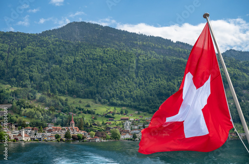Red Swiss flag at Lake Lucerne ferry  over Weggis village and Rigi mount.  Luzern, Switzerland. photo