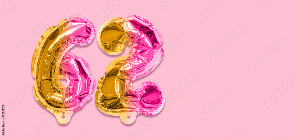 Rainbow foil balloon number, digit sixty two on a pink background. Birthday greeting card with inscription 62. Anniversary concept. Top view. Numerical digit. Celebration event, template. Banner
