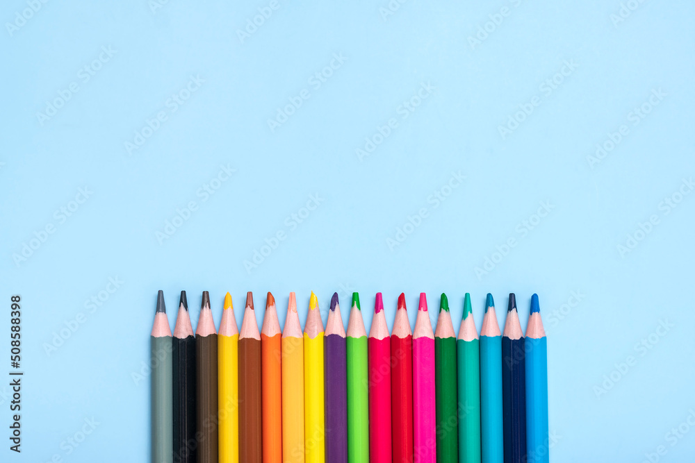 Fototapeta premium set of colored pencils isolated on blue background Top view Flat lay Education, craft concept Mock up