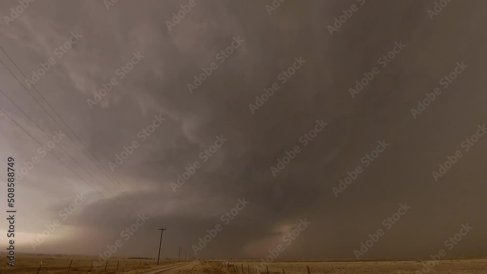 Lightning flashes as it strikes the ground in front of tornado ...