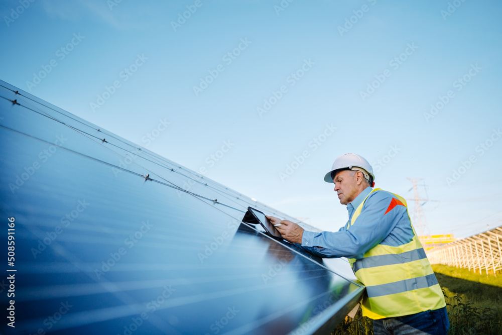 Solar engineer working with digital tablet at renewable energy farm. Alternative Eco energy concept Solar engineer working with digital tablet at renewable energy farm. Alternative Eco energy concept