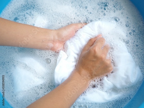 Shirt washing with detergent bubble in wash tub. top view  photo, blurred. photo