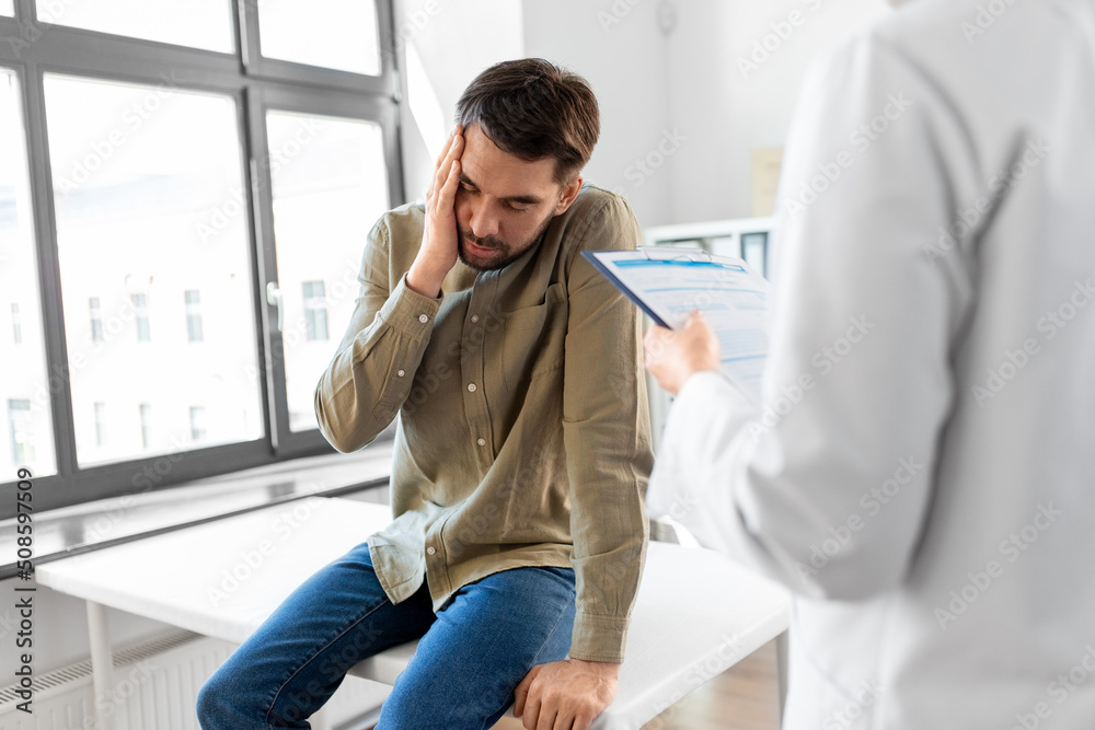 Obraz premium medicine, healthcare and people concept - female doctor with clipboard and sad male patient having health problem at hospital