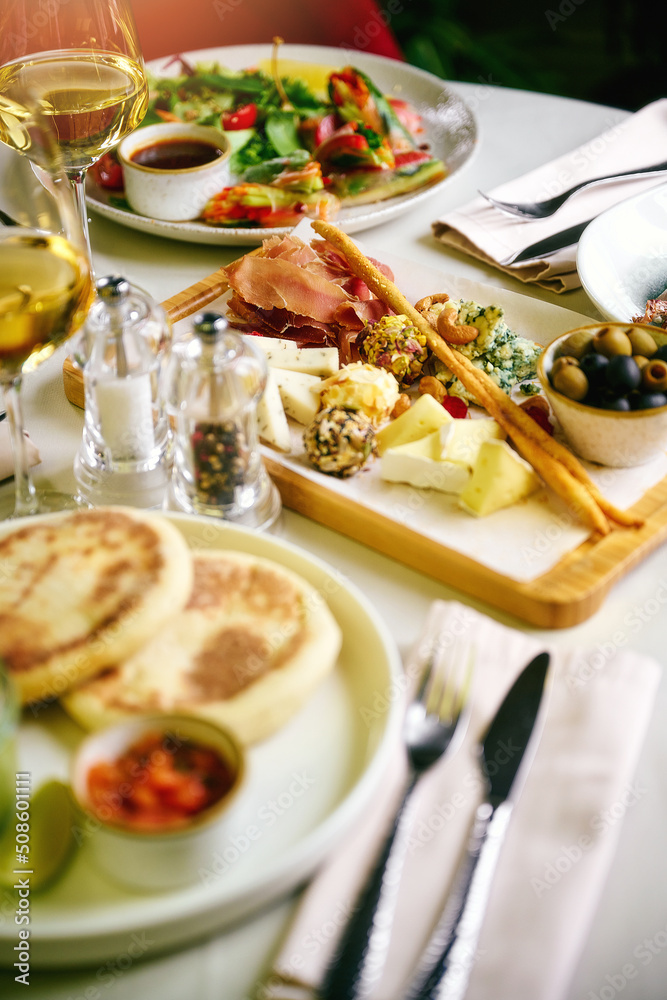 Breakfast served in cafe. Poached egg, tomato, avocado and sauteed spinach on pancakes with salad greens. Glass of sparkling wine. Breakfast served in cafe. Poached egg, tomato, avocado and sauteed spinach on pancakes with salad greens. Glass of sparkling wine.