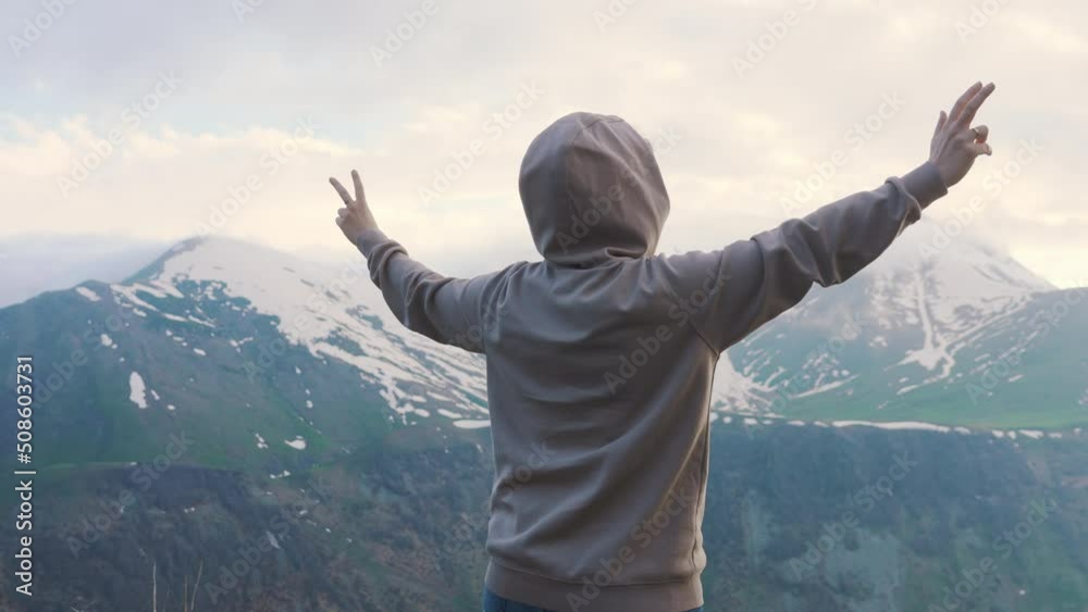 girl in the grey jacket spreading her arms and feeling free in the Caucausus mountains, Kazbegi, Georgia. High quality 4k footage girl in the grey jacket spreading her arms and feeling free in the Caucausus mountains, Kazbegi, Georgia. High quality 4k footage