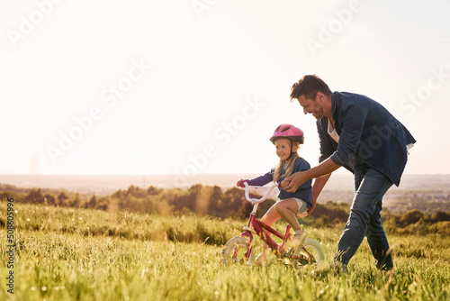 Fototapet Caucasian toddler learning how to ride bike