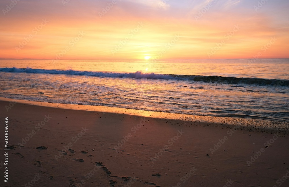 Purple sunset at the ocean, empty beach