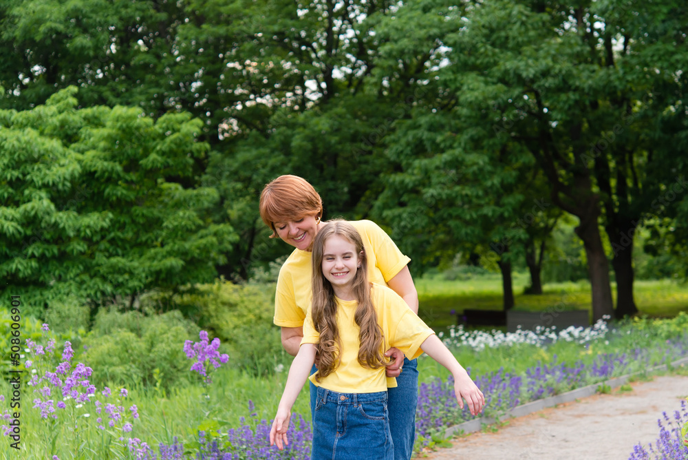 Fototapeta premium active mother and daughter walking along the path in the summer park