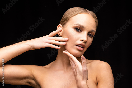 Tableau sur toile Young woman with bare shoulders and perfect fresh skin on black background