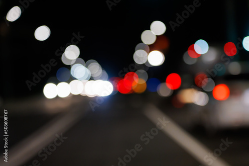 Valokuva Defocused night street view from drivers perspective, with bokeh blur of street lights