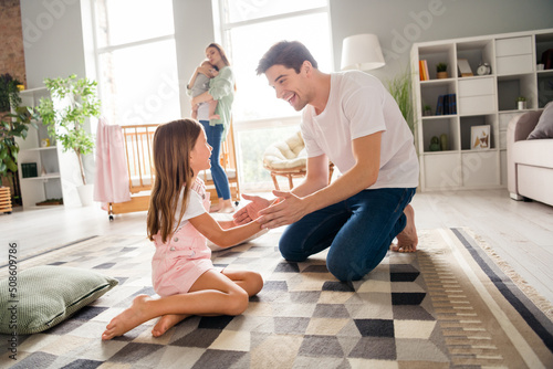 Fotografiet Photo of funny sweet husband wife little children father playing patty cake game