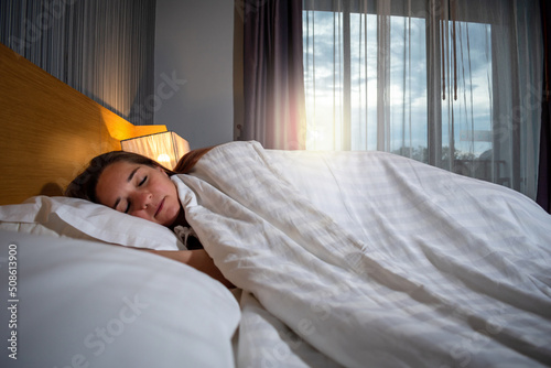 Mujer dormida recostada en su cama, teniendo un sueño placentero photo