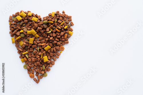top view of heart made of crunchy dry pet food isolated on white.