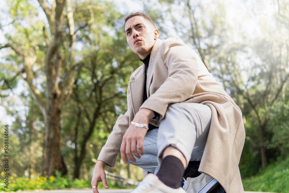 Obraz premium Young Hispanic Arab man crouching down posing on the road