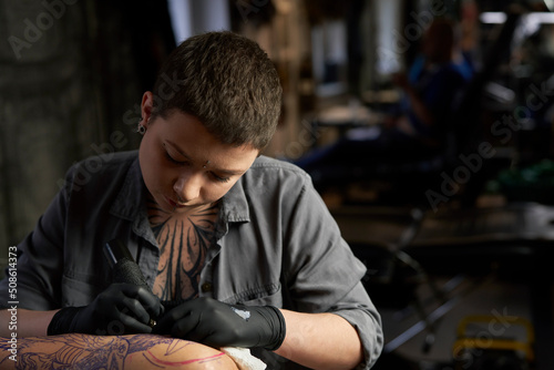 Close up of tattoo artist drawing on arm of client