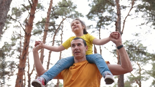Dad daughter walk park. father carries daughter around his neck in a forest park. happy family kid concept. father play with small child walk carries around his neck. happy family dream in the park