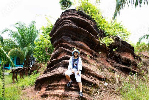 Travelers thai women travel visit and learn educate Fossilized stromatolite stone or fossil stromatoliths rock in geological heritage of UNESCO Geopark at La ngu on April 11, 2022 in Satun, Thailand photo