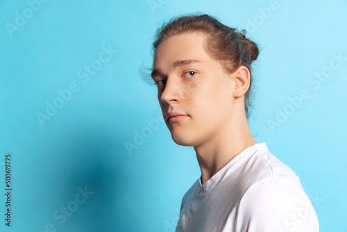 Closeup portrait of young man, student posing isolated on blue background. Human emotions, facial expression concept. Trendy colors