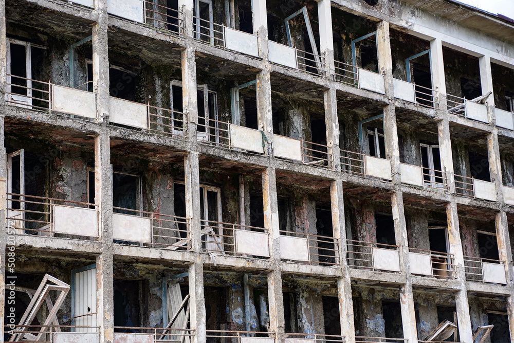 Fragment of an abandoned residential multi-storey building. Destroyed balconies, lack of windows and doors