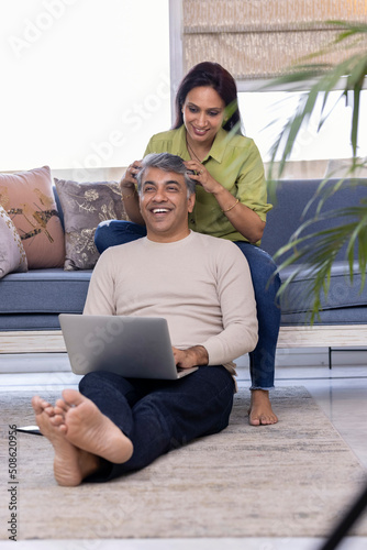 Canvas Print Indian woman giving a head massage to her husband at home.